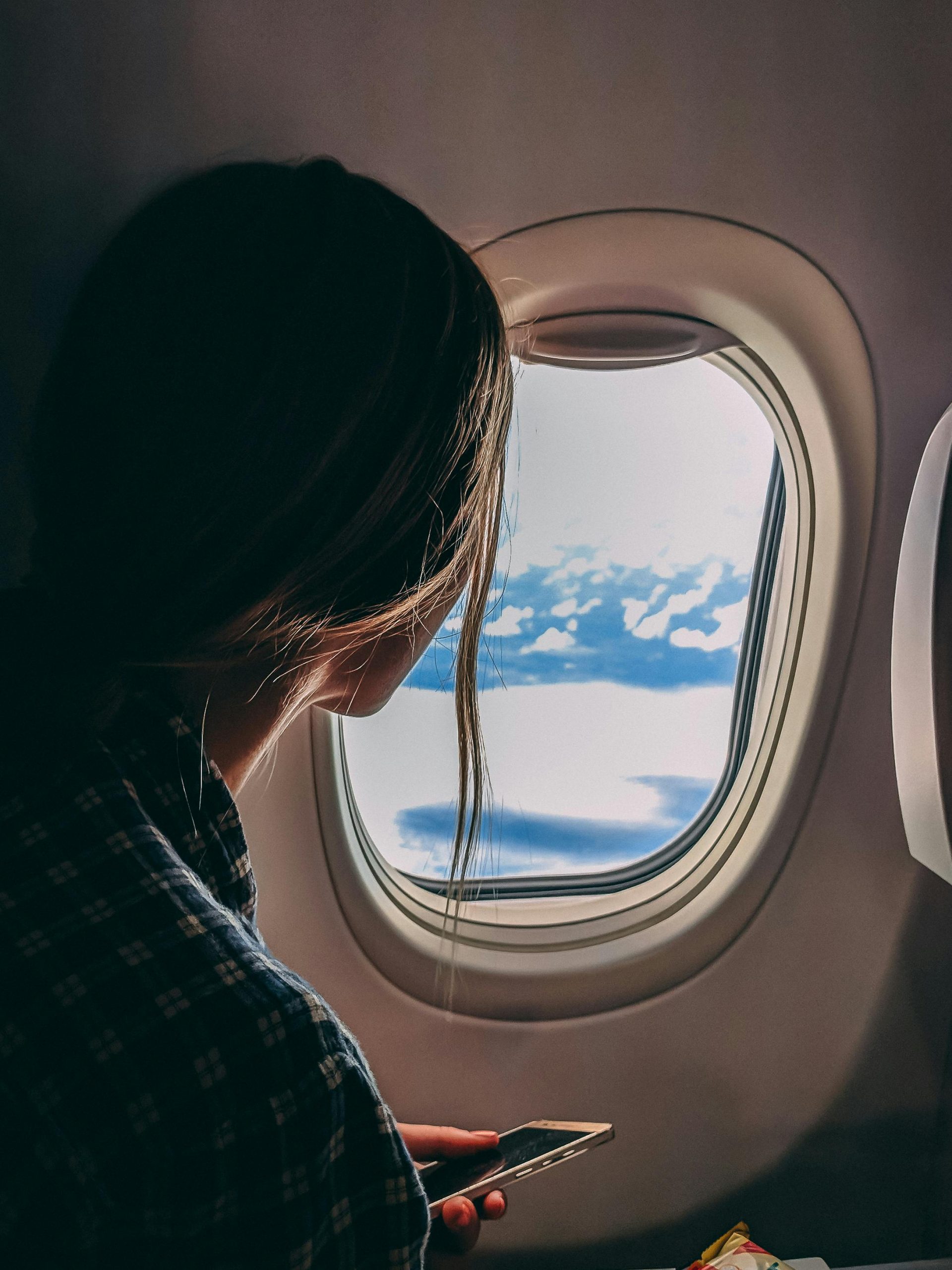 Woman looking out of airplane window